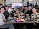 Lab team members pose around table while enjoying lunch together.