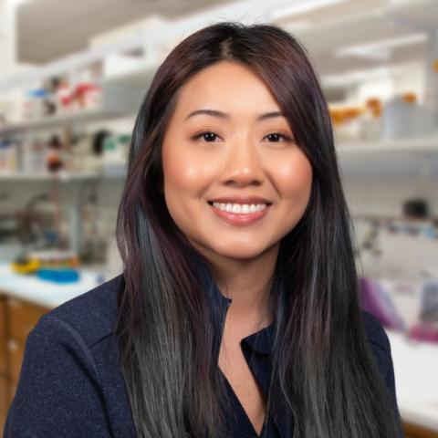 Katherine Tran wearing a black jacket standing in a research laboratory