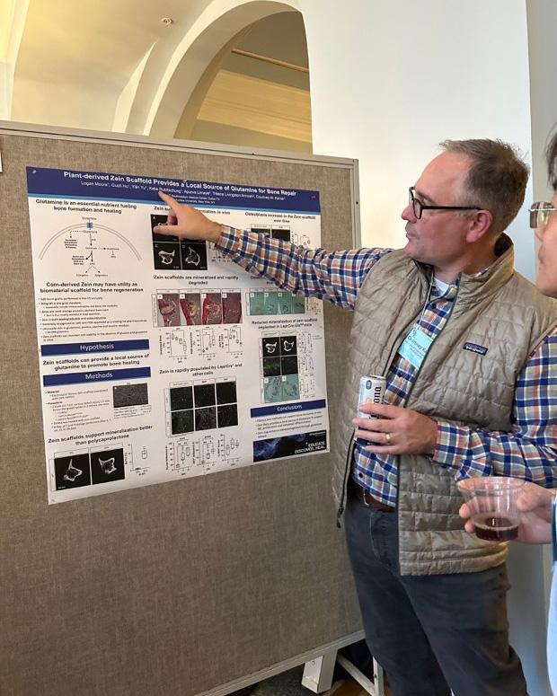 Dr. Karner standing in front of a research poster