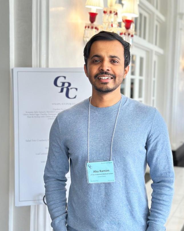 Dr. Ramim smiling in front of conference poster