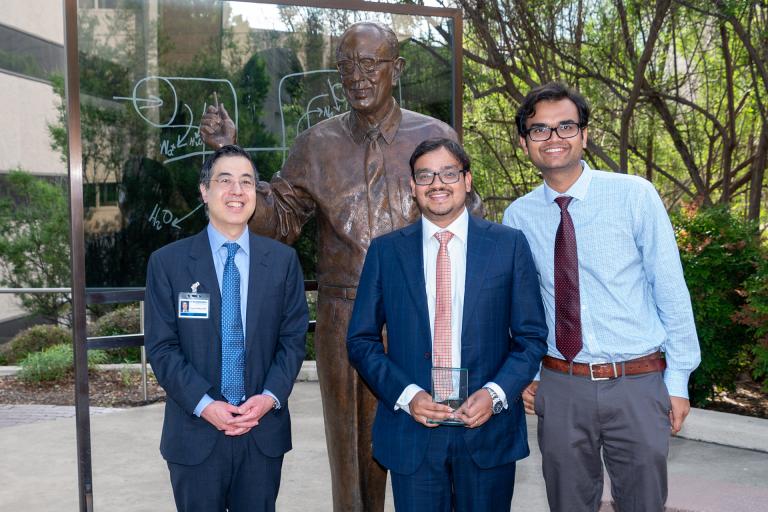 Dr. Thomas J. Wang, Dr. Sumitabh Singh and Dr. Abmarish Pandey standing infront of a statue of Dr. Donald Seldin