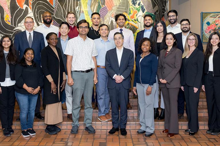 Cardiometabolic Research Unit lab members standing on a brick floor in front of an abstract painting 