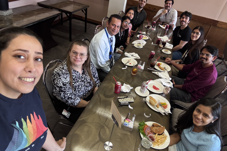 A group of people sitting at a long table while eating.