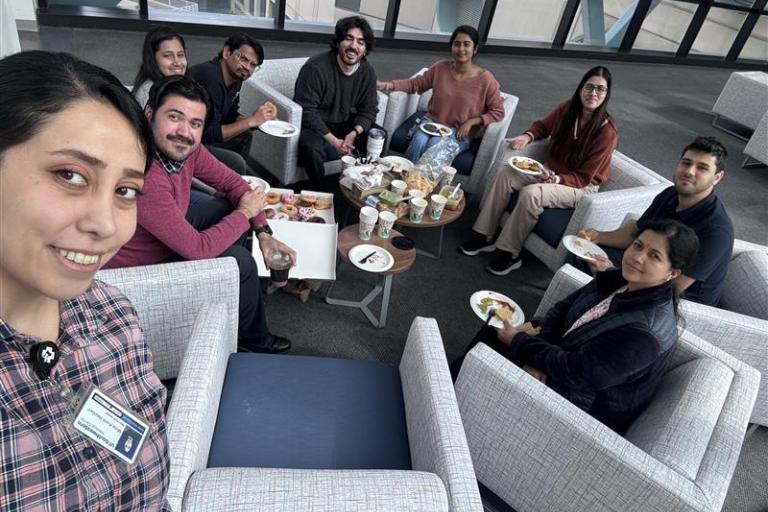 Ranjan Lab having donuts and coffee discussing events.