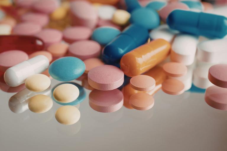 Pills spilled on top of reflective surface 