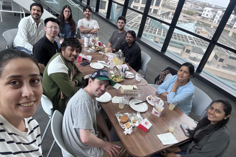Ranjan Lab group eating lunch together at a table in a lobby.