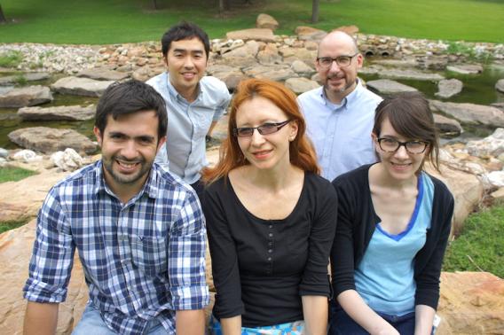 Lab Members sitting outdoors on boulders