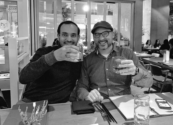 Nick talking science with Dr. Auinash Kalsotra and raising their glasses in a cheer