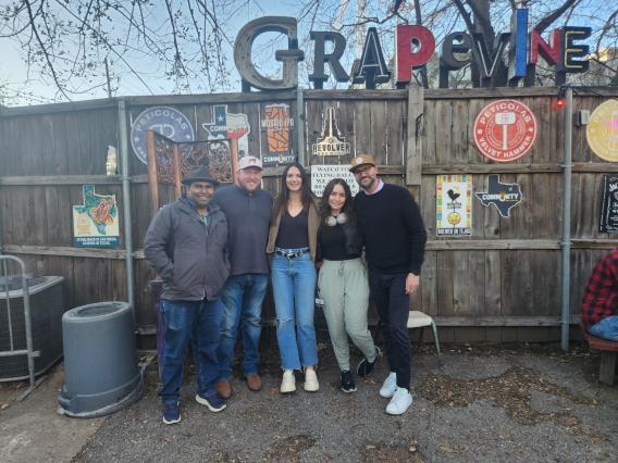 From left to right: Lorenzo, JD, Anna, Danielle and Mike pose for a photo below the sign for the Grapevine Bar. 