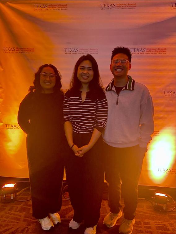 Three people posing together.