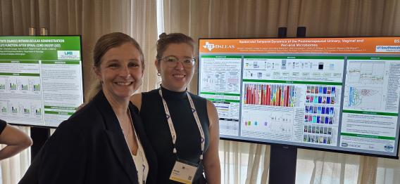 A student poses with her advisor and her digital poster.