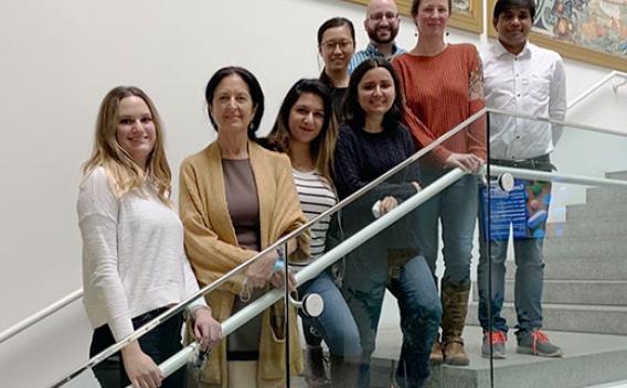 Conzen Lab members standing on stairs with metal railing