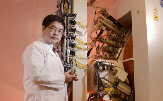 Xiankai Sun, Ph.D., with the GE PETtrace 880 cyclotron