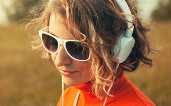 Girl in a field listening with headphones