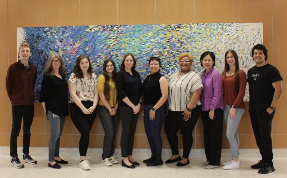 Lab Members standing in front of abstract painting