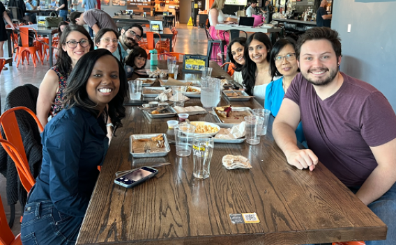 Group photo with Dr. Josephine Thinwa and the other lab members around a table at a restaurant.