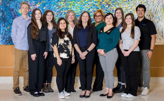 Lab Members standing in front of abstract painting