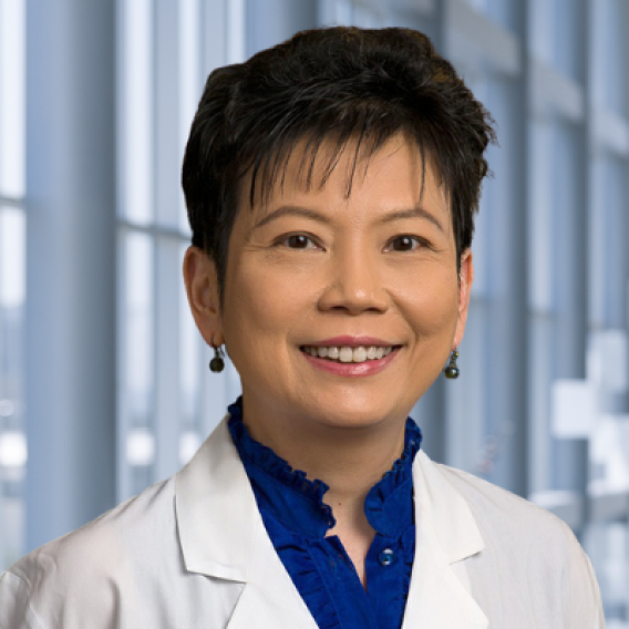 a woman with short hair wearing a white lab coat