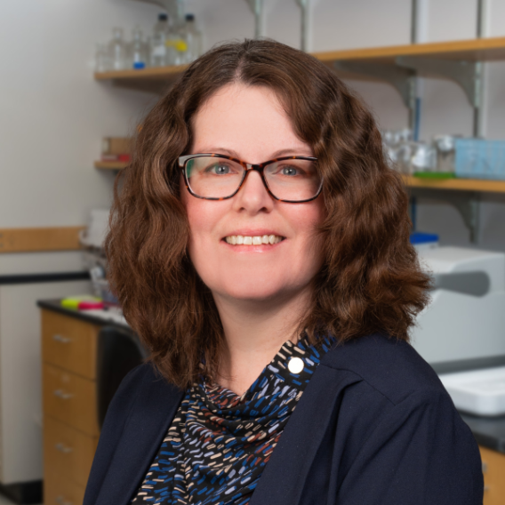 Christy Pybus, M.S., member of the David Greenberg Research Lab wearing a patterned shirt and a dark jacket