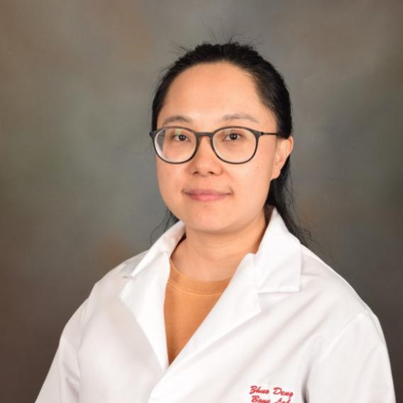 Dark-haired woman wearing glasses and a lab coat.