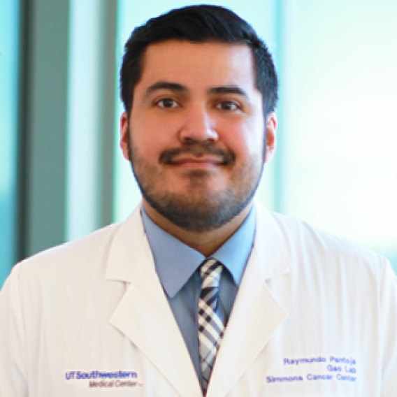 Dark-haired man with mustache and beard wearing lab coat.