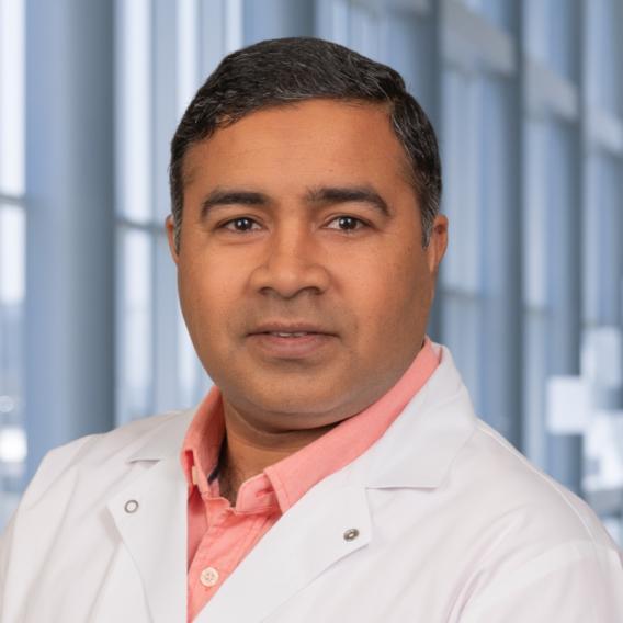 Mahesh Kathania wearing a white lab coat 