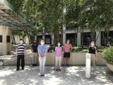 Lab group standing outdoors wearing masks and observing social distance