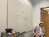 Lab member presenting information drawn on a whiteboard