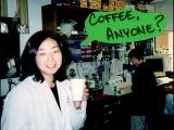 Lab member with Coffee and edited caption "Coffee Anyone?"