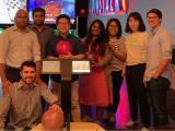 Eight lab members pose for the camera in front of bowling alley lanes