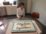 Kathryn Pendleton, PhD sitting with congratulatory cake