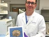 Jeffrey Waugh, M.D., Ph.D. holding a brain