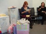 Olga opening gifts at Baby Shower while guest looks on