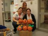 Three team members with six carved and decorated pumpkins