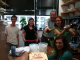 Team members celebrate Sarah Qual with cake and champaign