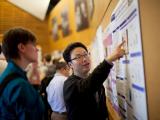 Two people looking at poster at Cold Spring Harbor Laboratory "The PARP Family and ADP-ribosylation" Meeting, 2014