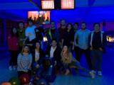 People in blue-lit bowling alley