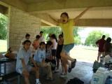 Lab group in pavilion at park, with one team member jumping in the air