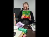 Pregnant woman holding "Goodnight Lab" book and laughing