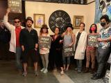 the lab group at an escape room venue wearing glasses and hats holding signs