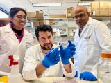 A female and male lab member work alongside Dr. Malladi in lab