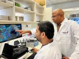 A male lab member works alongside Dr. Malladi in lab