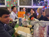 several people sitting around a dinner table with Christmas decorations.