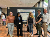 five people stainding in front of a scientific poster display