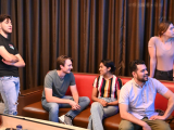 Three men and two woman candidly pose for the camera at a bowling alley