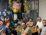 Malladi Lab members sitting around table in a festively decorated room