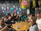 Malladi Lab members sitting around table in a festively decorated room