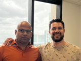 Dr. Malladi and Mauricio pose for the camera in front of a window