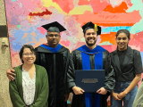 Dr. Malladi and Mauricio in cap and gown pose for the camera alongside two women