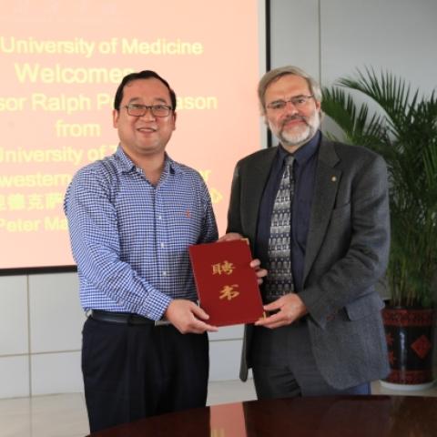 HUM president Tu Hanjun, left, presented a certificate to Dr. Mason.